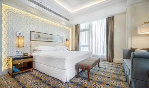 um quarto de hotel com uma cama grande e um sofá em Sheraton Grand Wuhan Hankou Hotel - Let's take a look at the moment of Wuhan em Wuhan