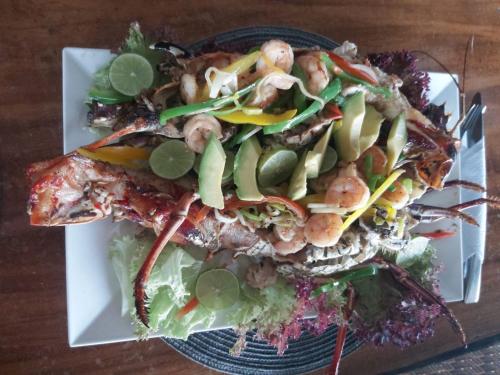 a plate of food with shrimp and vegetables on it at Hotel Casa Barlovento, Parque Tayrona in Los Naranjos