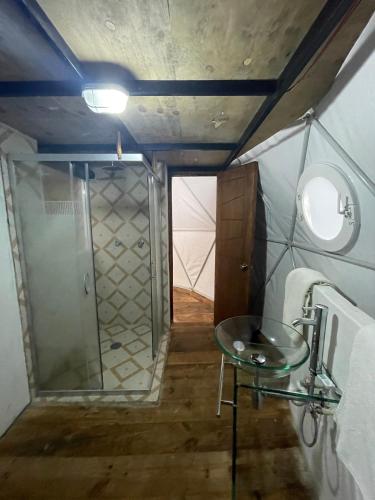 a bathroom with a shower and a glass table at MANDALA CAMP in Tomatlán