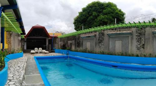 a blue swimming pool in front of a building at 2 Hotel Saleh in Angeles