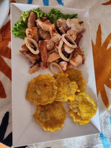 a plate of food with shrimp and other foods at Hotel Casa Barlovento, Parque Tayrona in Los Naranjos