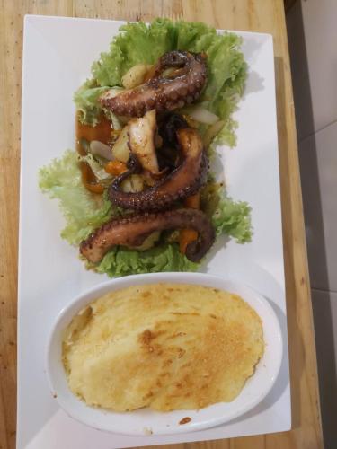 a plate of food with sausage and lettuce on a table at Hotel Casa Barlovento, Parque Tayrona in Los Naranjos