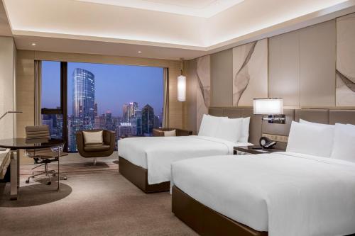 a hotel room with two beds and a desk at JW Marriott Hotel Chengdu in Chengdu