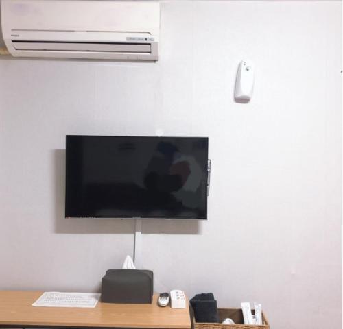 a tv hanging on a wall above a desk at Dam Stay Jeju in Jeju