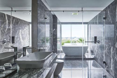 a bathroom with a tub and a sink and a bath tub at Yogyakarta Marriott Hotel in Yogyakarta