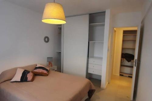 Schlafzimmer mit einem Bett und einer Leuchte in der Unterkunft Departamento moderno en Las Lomitas in Partido Lomas de Zamora