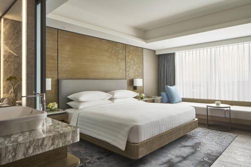 1 dormitorio con cama, bañera y lavamanos en Yogyakarta Marriott Hotel en Yogyakarta