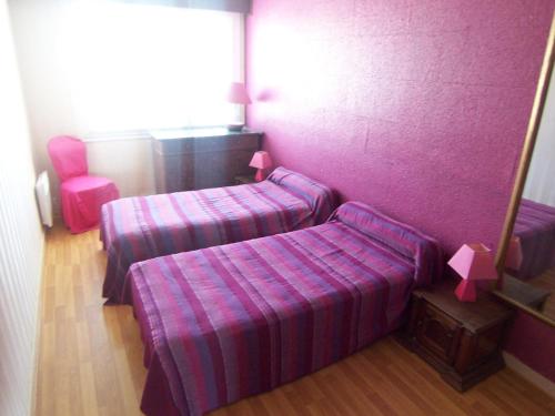 Habitación con 2 camas y pared púrpura. en Appartement Les Sables-d'Olonne, 3 pièces, 6 personnes - FR-1-197-169, en Les Sables-dʼOlonne
