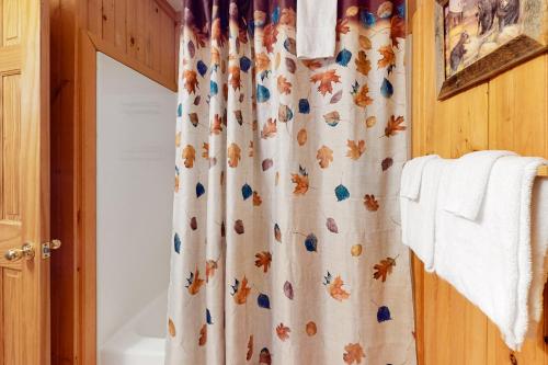 a bathroom with a shower curtain with autumn leaves on it at The Hydeaway in Hiawassee