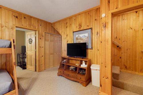 a bedroom with wooden walls and a television on a cabinet at The Hydeaway in Hiawassee