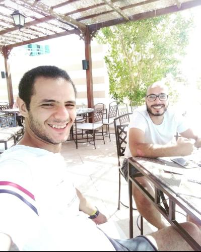 dois homens sentados numa mesa num restaurante em ادهم هيبه em Alexandria