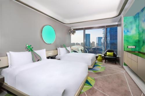 a hotel room with two beds and a large window at W Suzhou - Jinji Lake in Suzhou