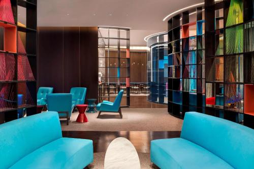 a library with blue chairs and bookshelves at W Suzhou - Jinji Lake in Suzhou