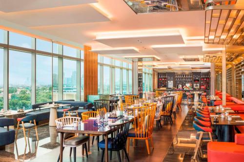 a restaurant with tables and chairs and windows at W Suzhou - Jinji Lake in Suzhou
