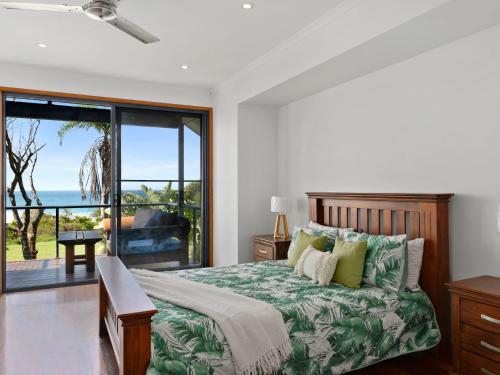Arrawarra的住宿－Surf Break，一间卧室配有一张床,享有海景