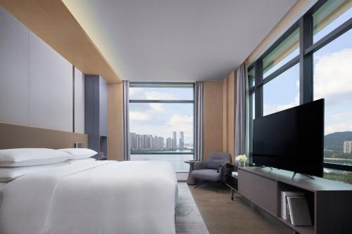 a hotel room with two beds and a flat screen tv at The Meixi Lake, Changsha Marriott Executive Apartments in Changsha