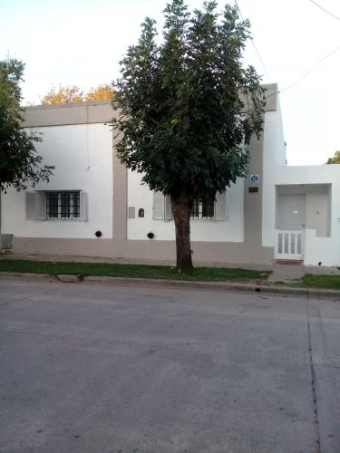 een wit gebouw met een boom ervoor bij Los Abuelos in Dolores