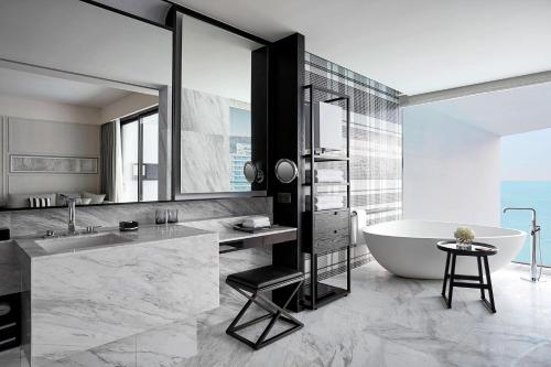 a bathroom with a tub and a sink and a bath tub at The Shanhaitian Resort Sanya, Autograph Collection in Sanya