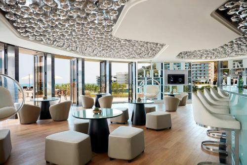 a restaurant with white chairs and tables and windows at The Shanhaitian Resort Sanya, Autograph Collection in Sanya