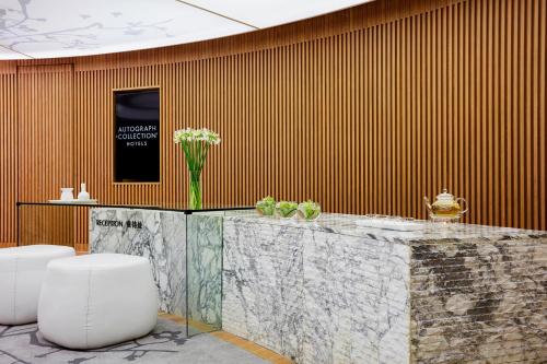 a lobby with a table with a vase of flowers on it at The Shanhaitian Resort Sanya, Autograph Collection in Sanya