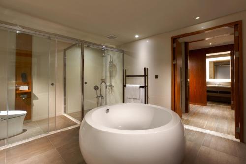 馬公市的住宿－澎湖福朋喜來登酒店，一间带大型白色浴缸和淋浴的浴室