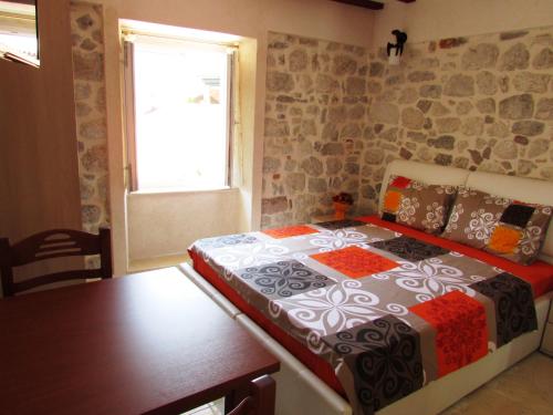 a bedroom with a bed and a table and a window at Apartments Popovic in Kotor