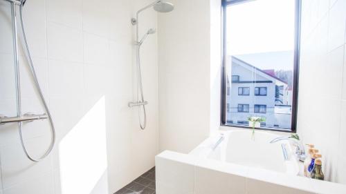 a white bathroom with a shower and a sink at hirafu188 in Kutchan