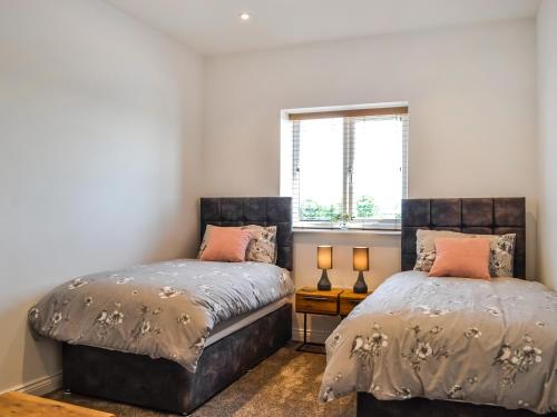 um quarto com 2 camas e uma janela em Fell View Cottage - Uk43378 em Kirklinton