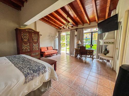 a bedroom with a bed and a living room at Hacienda de las Flores in San Miguel de Allende