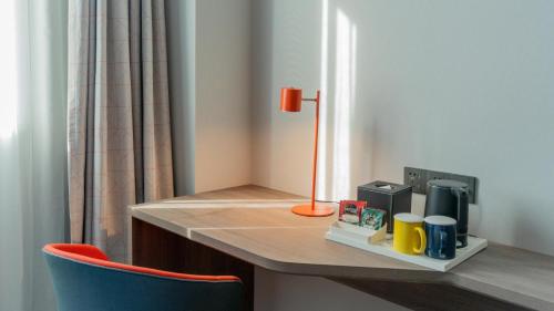 a room with a desk with a lamp and a chair at Holiday Inn Express Nantong Xinghu, an IHG Hotel in Nantong