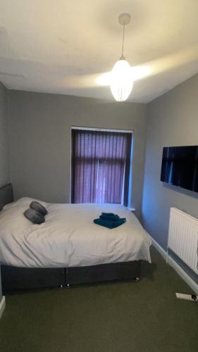 a bedroom with a bed with a window and a television at Imperial Suites in Bradford
