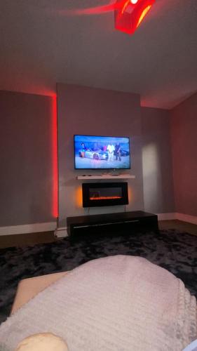 a living room with a flat screen tv on a wall at Imperial Suites in Bradford