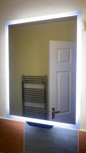 a mirror on a wall with a door in a room at Imperial Suites in Bradford