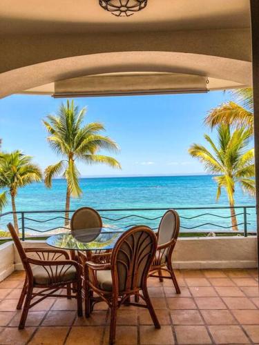 a table and chairs on a balcony with a view of the ocean at "Condo Delfines" acogedor espacio en la playa ! in La Paz