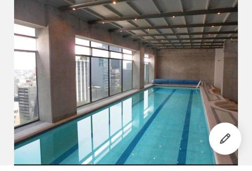 una grande piscina in un edificio con finestre di Loft Reforma Downtown Pool/Jacuzzi/Gym/Roof Top a Città del Messico