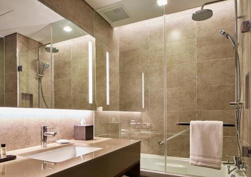 a bathroom with a sink and a glass shower at Four Points by Sheraton Josun, Seoul Station in Seoul