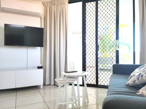a living room with a couch and a table and a tv at Mooloolaba Beach Club Paradise 2 Bedroom Apartment in Mooloolaba