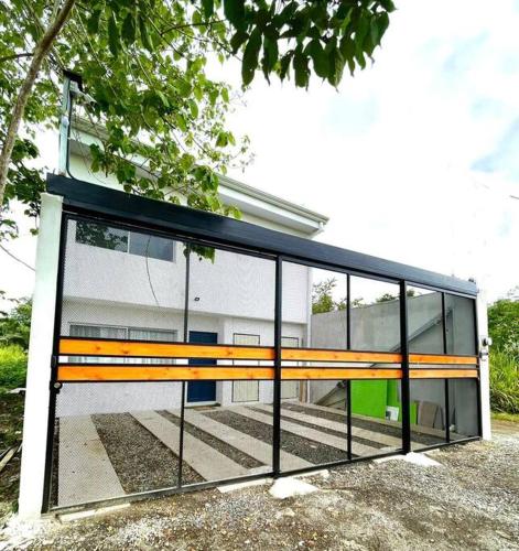 a glass building with a bench in front of it at Pacific Breeze House - with private pool in Jacó