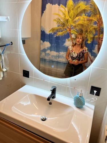 a woman standing in front of a sink in a bathroom at Oostende City Center Yellow in Ostend