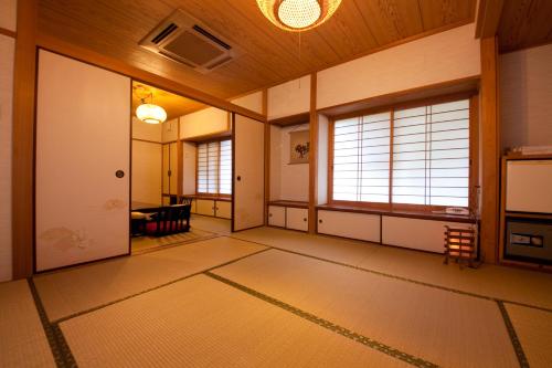 a japanese room with doors and windows in a room at Oyado Uraku in Yufu