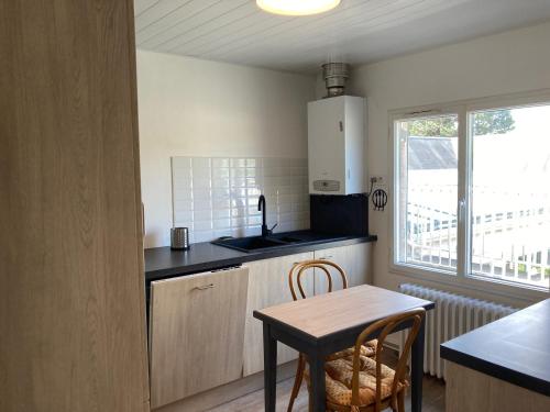 - une cuisine avec une table, une petite table et des chaises dans l'établissement Charmant appart rénové pour 6, à 5 min de la plage et du centre, avec parking - Trouville - FR-1-712-65, à Touques