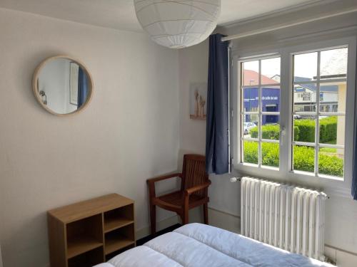 une chambre avec un lit, une fenêtre et un miroir dans l'établissement Charmant appart rénové pour 6, à 5 min de la plage et du centre, avec parking - Trouville - FR-1-712-65, à Touques