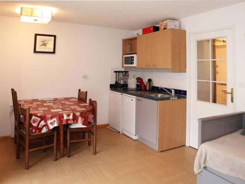 une cuisine avec une table et une petite cuisine avec une table et des chaises dans l'établissement Studio aux Orres 1800m avec Piscine, Terrasse, et Accès Direct aux Pistes - FR-1-322-525, aux Orres