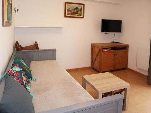 a living room with a couch and a flat screen tv at Appartement Les Orres, 1 pièce, 4 personnes - FR-1-322-525 in Les Orres