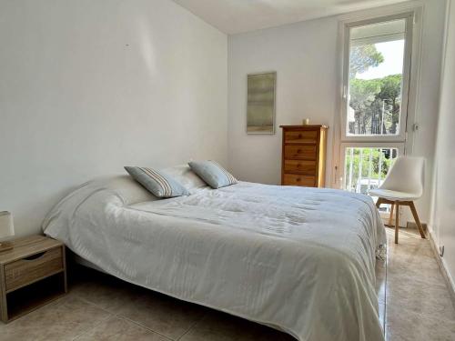 une chambre blanche avec un lit et une fenêtre dans l'établissement Appartement 3 pièces, front de mer, accès direct plage, équipements modernes - FR-1-225-796, à Argelès-sur-Mer