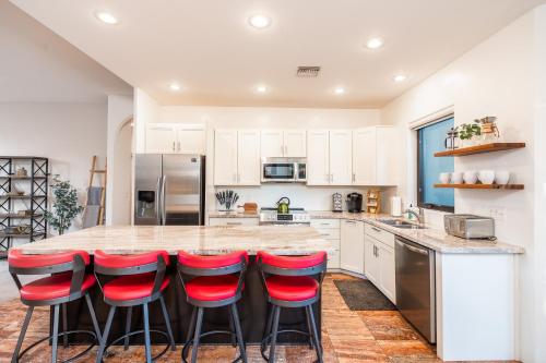 a kitchen with a large island with red bar stools at WEST SEDONA RETREAT w/ VIEWS of Coffee Pot Rock! in Sedona