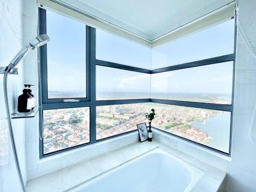 a bath tub in a bathroom with a large window at SilverScape l A4011 l Luxury 3BR l Bathtub l 6-11 pax l Seaview l Infinity Pool l Jonker Street l City Centre by Jay Stay in Melaka