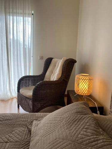a bedroom with a bed and a chair and a lamp at A casa das minhas netas in Caldas da Rainha
