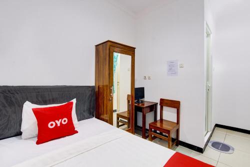 um quarto com uma almofada vermelha numa cama em OYO 92479 Pasadena House em Semarang