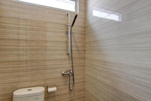 um chuveiro na casa de banho com um WC e uma janela em OYO 92479 Pasadena House em Semarang